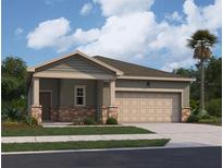 Charming single-story home showcasing a two-car garage, landscaped yard, and neutral color palette under a sunny sky at 14699 Italy Ave, Dade City, FL 33523