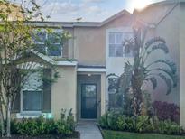 Charming two-story home with landscaped yard, lush greenery, and inviting entryway at 6122 Osprey Lake Cir, Riverview, FL 33578