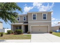 Inviting two-story home with a well-maintained lawn and a two-car garage at 11807 Myrtle Rock Dr, Riverview, FL 33578