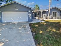 Charming single-story home with an attached two-car garage and well-maintained lawn at 1404 Rosewood Ave, Dunedin, FL 34698