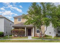 Charming two-story home featuring manicured lawn, mature landscaping, and covered porch at 13417 Lake Monroe Pl, Riverview, FL 33579
