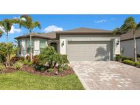 Beautiful single-story home featuring a well-manicured front yard with lush landscaping at 10735 Spring Tide Way, Parrish, FL 34219