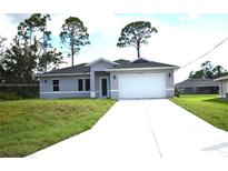 Charming single-story home featuring a well-manicured lawn and a two-car garage at 3092 Crowder St, Port Charlotte, FL 33980