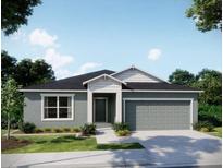 Charming single-story home featuring a gray exterior, well-manicured lawn, and a two-car garage at 25290 Puerta Dr, Punta Gorda, FL 33955