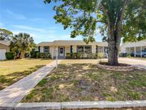Charming single-story home features a well-maintained lawn, classic design, and inviting walkway at 1115 31St W St, Bradenton, FL 34205