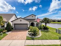 Charming single-Gathering home showcasing manicured landscaping, an inviting entrance, and a two-car garage at 18743 Coastal Shore Ter, Land O Lakes, FL 34638