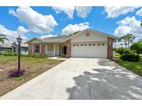 Charming single-story home featuring a two-car garage and well-maintained front yard landscaping at 2436 Deer Trail Ln, Spring Hill, FL 34606