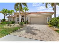 Stunning single-story home boasts a lush tropical landscape, paver driveway, and attached two-car garage at 3629 Licata Ct, Punta Gorda, FL 33950