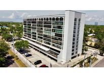 Stunning aerial view of a modern condo building with a well-maintained parking area and beautiful landscaping at 3211 W Swann Ave # 408, Tampa, FL 33609
