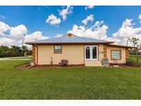 Charming single-story home with a well-manicured lawn and a blue metal roof, perfect for low maintenance living at 3400 Dawson Ln, Punta Gorda, FL 33950