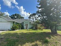 Charming single-story home featuring a well-maintained lawn and beautiful landscaping at 21285 Peachland Blvd, Port Charlotte, FL 33954