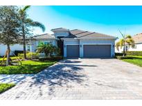 Charming single-story home features a symmetrical facade, attached two-car garage, lush landscaping, and a brick-paved driveway at 25301 Longmeadow Dr, Punta Gorda, FL 33955