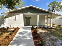 Charming single-story home with a covered porch, manicured landscaping, and a stone-textured facade at 961 Charlotte Ave, Sarasota, FL 34237
