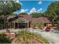 Community exterior showing landscaping, parking, and brick facade at 8653 Fancy Finch Dr # 102, Tampa, FL 33614