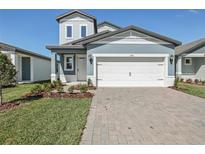 Charming two-story home featuring a two-car garage, nicely manicured lawn and stylish exterior paint at 1869 Brekey Way, Zephyrhills, FL 33541