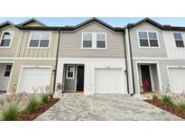 Charming townhouse featuring a paver driveway and attached one-car garage at 7272 Deer Valley Circle, Tampa, FL 33635