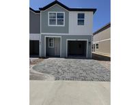 Charming two-story townhouse with a two car garage and a brick paved driveway at 7274 Deer Valley Cir, Tampa, FL 33635