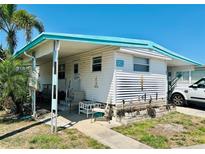 Charming single-story home featuring a covered porch, carport and manicured landscaping at 9790 66Th N St # 238, Pinellas Park, FL 33782