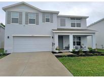 Charming two-story home with a well-manicured lawn, covered porch, and light blue exterior at 3715 Capri Coast, Plant City, FL 33565