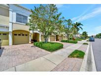 Inviting townhomes featuring attached garages, well-manicured landscaping, and brick paved driveways at 4062 Overture Cir # 4062, Bradenton, FL 34209