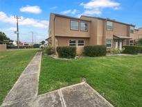 Charming townhome with well-maintained lawn and mature landscaping under a blue, cloudy sky at 1857 Clearbrooke Dr, Clearwater, FL 33760