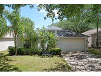 Charming single-Gathering home featuring lush landscaping and a cozy front porch bench at 13405 Fawn Springs Dr, Tampa, FL 33626