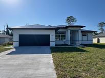Charming single-Gathering home featuring a well-maintained lawn, a driveway, and a two-car garage at 2551 Alhaven Ter, North Port, FL 34286