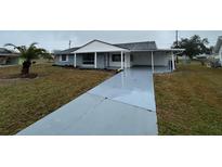 Charming single story home featuring a covered carport and a well-manicured front yard at 702 Desert Hills Way, Sun City Center, FL 33573