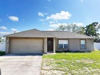 Charming single-story home featuring a two-car garage and well-lit porch at 12092 Rockford St, Spring Hill, FL 34608