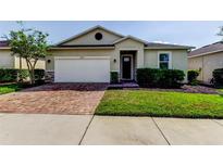 Charming single-story home with a brick driveway, attached garage, and well-manicured landscaping at 25242 Carnation Sedge Way, Land O Lakes, FL 34639