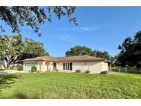 Charming single-story home with a well-manicured lawn and beautiful, mature landscaping at 3652 Oak Grove Dr, Sarasota, FL 34243