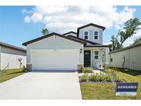 Charming home featuring a two-car garage, manicured lawn, and a welcoming front entrance at 3904 Radiant Mountain Dr, Plant City, FL 33565