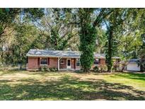 Charming one-story brick home with a well-maintained front yard and mature trees at 2902 Little Rd, Valrico, FL 33596