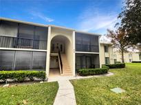 Charming two-story condo with a landscaped front yard, inviting entrance, and screened in patios at 1424 Pine Glen Ln # D2, Tarpon Springs, FL 34688