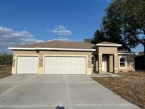 Charming single-story home with a large two-car garage and well-lit front porch at 2346 Logsdon St, North Port, FL 34287