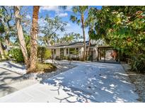 Wide driveway with white gravel and lush greenery, leading to a charming home at 913 Tennessee Ln, Sarasota, FL 34234