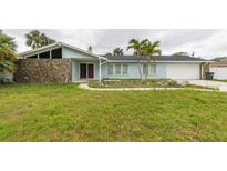 Charming single-story home featuring stone accents and a well-maintained front lawn with mature landscaping at 819 Jacaranda Dr, Largo, FL 33770