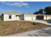 Charming single-story home featuring a two-car garage and freshly landscaped yard at 2310 Logsdon St, North Port, FL 34287
