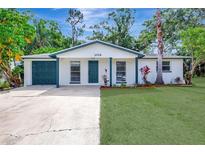 Charming one-story home featuring a well-maintained lawn and a painted brick facade, complimented by colorful landscaping at 1024 Applewood Dr, Clearwater, FL 33759