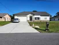 Charming single-story home with well-maintained lawn, long driveway and two car garage at 4666 Clarke St, North Port, FL 34286