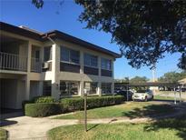 Well-maintained building exterior with manicured landscaping and covered parking at 4826 Marine Pkwy # 202, New Port Richey, FL 34652