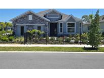 Charming single-Gathering home featuring a beautifully landscaped front yard and modern architectural details at 9544 Vibrant Lane, Venice, FL 34292
