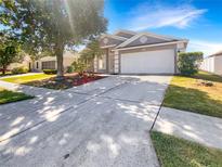 Charming single-story home featuring a well-manicured lawn, two-car garage, and inviting curb appeal at 30406 Arrochar St, Wesley Chapel, FL 33545