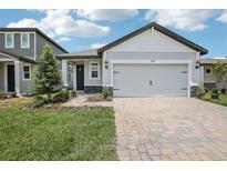 Charming single-Gathering home with a two-car garage and a beautifully landscaped front yard at 1839 Brekey Way, Zephyrhills, FL 33541