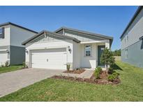 Charming single-story home with a well-manicured lawn, a two-car garage, and inviting curb appeal on a sunny day at 1861 Brekey Way, Zephyrhills, FL 33541