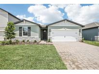 Charming single-story home with a well-manicured lawn and a two-car garage at 1870 Draughton Dr, Zephyrhills, FL 33541