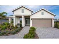 Charming two-story home with a two-car garage, beautifully landscaped front yard, and a welcoming walkway at 9548 Vibrant Lane, Venice, FL 34292