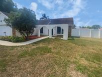 Charming home exterior with arched entry, healthy tree, and a low-maintenance landscaped yard at 22162 Weeks Blvd, Land O Lakes, FL 34639