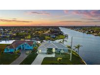 Waterfront home features lush landscaping, metal roof, and canal access at 9277 St Paul Dr, Port Charlotte, FL 33981