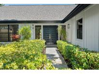 Inviting front entrance with lush landscaping and stylish, modern double doors at 5474 Dominica Cir, Sarasota, FL 34233